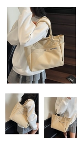 Detail of off-white canvas tote bag featuring reinforced handles and embroidered logo
