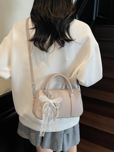 Elegante borsa in pelle beige con ciondolo a fiocco in pizzo e tracolla rimovibile