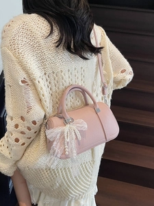 Borsa a mano Boston rosa trama litchi con fiocco di pizzo e ciondolo di perla sul modello