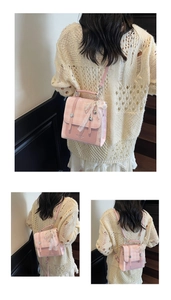 Detail of pink plaid mini backpack with white lace, bow charms, and metallic buckles