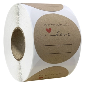 Macro shot of 2-inch homemade with love kraft paper stickers with red heart and writing lines