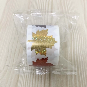 Macro shot of laser maple leaf stickers with gold glitter texture and seasonal colors
