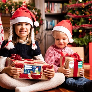 Kids holding gift boxes with Christmas gift tags featuring Santa and reindeer designs