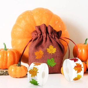 Detail of autumn maple leaf drawstring linen gift bag with rolls of decorative stickers