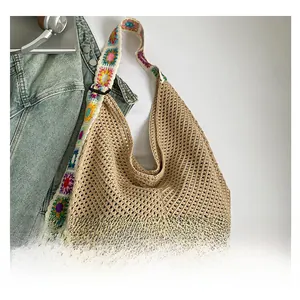 Detail of khaki woven beach tote featuring colorful crochet strap and hollow knit pattern