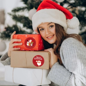 Roll of Merry Christmas stickers with Santa and Snowman for holiday gift box sealing