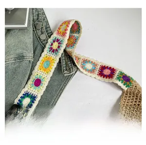 Detail of bohemian handmade crochet shoulder bag with colorful floral strap and mesh pattern