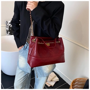 Close-up of quilted burgundy leather tote bag with gold chain strap and turn-lock closure