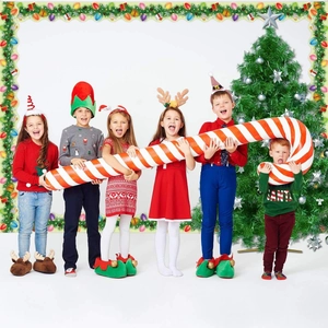 Enfants en costumes de Noël avec cannes en sucre gonflables et décorations de fête