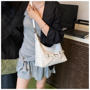 Détail d'un sac hobo en cuir verni blanc avec bandoulière réglable et boucle en métal