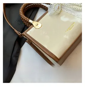 Detail of vintage square handbag with woven handle and cream brown leather texture