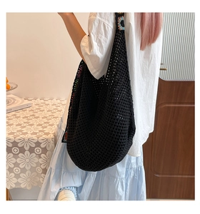 Detail of black crochet tote bag featuring colorful hand-knit floral accents on the strap