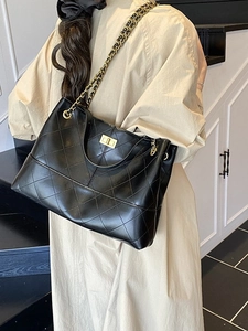 Quilted black leather tote bag with gold chain strap and turn-lock closure on shoulder