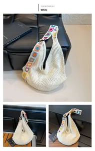 Detailed close-up of white crochet hobo bag with a colorful bohemian floral woven strap