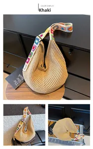Detail of khaki knit tote with wide colorful floral embroidered strap on a wooden stool