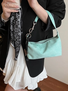 Mint green matte underarm bag with silver buckle worn by model in a black blazer