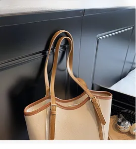Détail du sac cabas contrasté avec bandoulière réglable et texture de cuir chic
