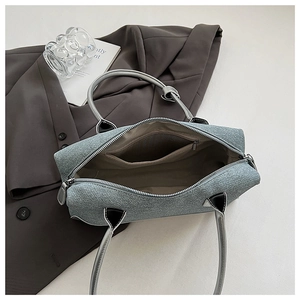 Detail of denim tote bag showing spacious interior with zipper pocket and leather handles