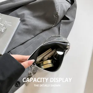 Macro shot showing internal storage capacity for lipstick and makeup in silver chain bag