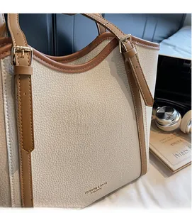 Détail du sac cabas bicolore montrant le cuir grainé et les boucles dorées raffinées