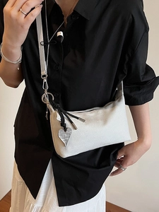 Minimalist light gray underarm bag with silver heart charm and black rope detail