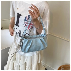 Detail showing light blue pleated cloud bag with woven handle and silver chain accessory