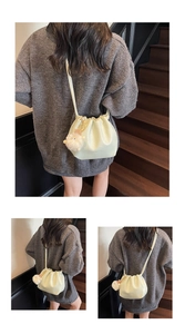 Detail of drawstring bucket bag with cute plush sheep pendant on wooden stairs