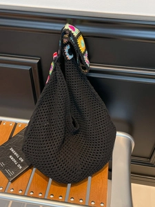 Large black knit tote bag with colorful sunflower crochet handles for beach and summer