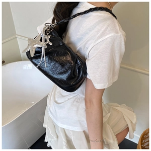 Detail of black wrinkled oil wax leather handbag with silver star and rabbit charms