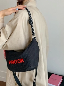 Quilted black hobo shoulder bag with red Pantor embroidery and rope strap on a model