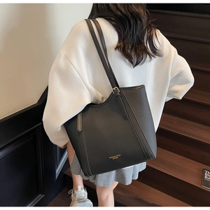 Détail du grand sac cabas noir en cuir grainé avec bandoulière réglable et logo doré