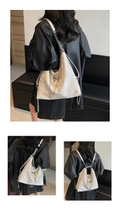 Detail of white glossy embossed tote bag featuring silver chain and pearl decorations