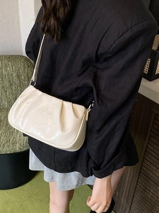 Chic cream oil-wax leather shoulder bag with stylish pleats and a glossy finish