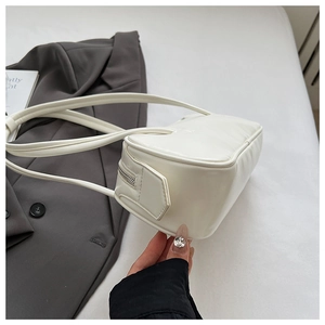 Detailed side view of a white minimalist faux leather shoulder bag with zipper closure