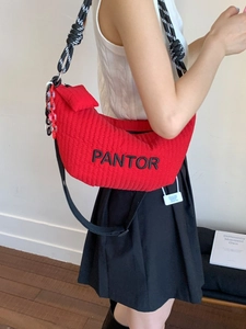 Red quilted crescent bag with braided strap and small pouch shown on model