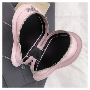 Detail showing the black interior and zipper of the pink heart-shaped crossbody bag