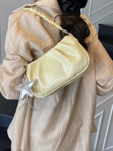 Chic pleated cream cloud bag with a braided strap and silver star pendant accessory