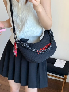 Quilted black crescent bag with red embroidery and woven handle for casual street style