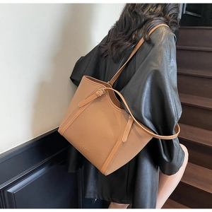 Détail du cabas caramel en cuir grainé avec bandoulière réglable et boucle dorée