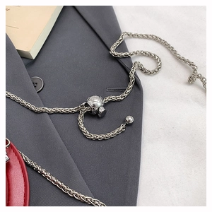 Detail of silver woven chain strap with adjustable metal ball buckle and red leather accent