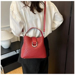 Detailansicht einer roten geflochtenen Eimertasche aus Leder mit silberner D-Ring Schnalle