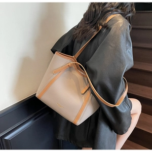 Détail du sac cabas minimaliste montrant le cuir contrasté et le logo doré élégant