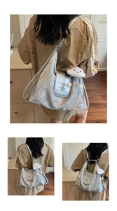 Detail eines silbernen Rucksacks mit Sternschnalle, Nieten und weißem Wolkenanhänger