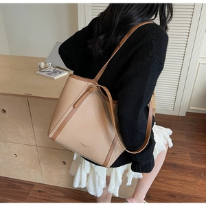 Détail du sac cabas contrasté avec texture grainée et logo doré embossé de luxe