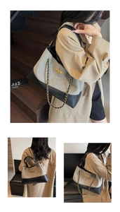 Detail of two-tone quilted tote bag with gold twist lock and metal chain strap