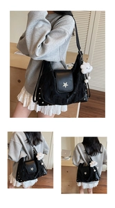 Detail der schwarzen Nylon-Schultertasche mit silberner Sternschnalle und Plüsch-Anhänger