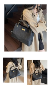 Close-up of black quilted shoulder bag with gold chain strap and metallic lock detail
