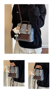 Detail of retro denim backpack with brown leather trim and white plush doll pendant charm