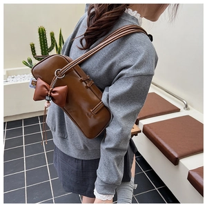 Chic brown synthetic leather shoulder bag with decorative bow charm and slim double straps