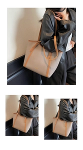 Détail d'un grand sac cabas contrasté en cuir litchi beige avec bandoulières marron